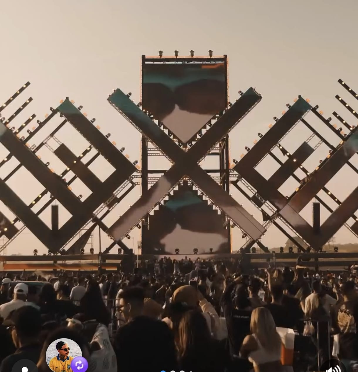 Palco de festival com estrutura geométrica e público em frente